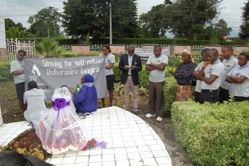 Abakozi ba hotel la Palme bashyira indabyo ku rwibutso rwa Muhoza.