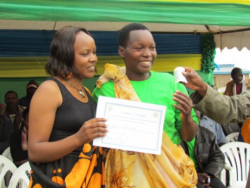 Bayavuge Bernadette ahabwa cheque na Rose Ndejeje Uwineza, Umuyobozi w