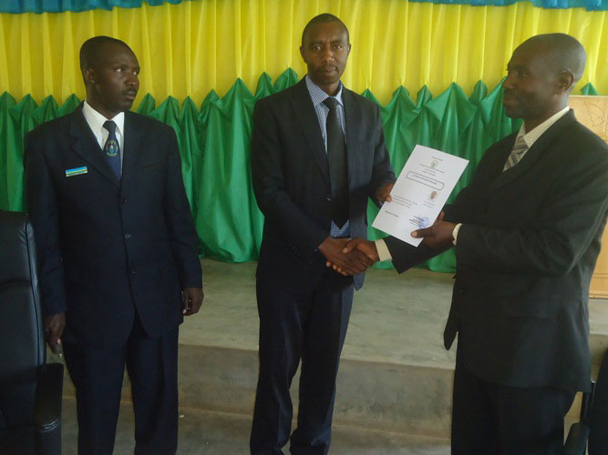 Aha Ndiricima arashyikirizwa n'umuyobozi w'akarere ka Ruhango icyemezo cy'uko yabaye Umunyarwanda./Foto: Eric Muvara
