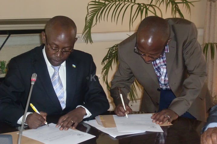 Umwe mu bayobozi ba za TTC ashyira umukono ku masezerano y'impano y'imodoka.