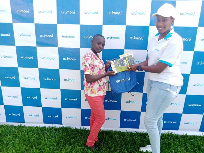 Uwamahoro Cathia ashyikiriza impano umwe muri abo bana