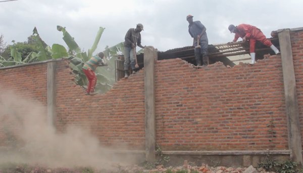 Ubwo umuhesha w'inkiko yamaraga kubahiriza icyemezo cy'urukiko, bahise basenya urukuta uwo munyamahanga yari yarubatse ubwo yamaraga gusohora abaturage mu mitungo yabo