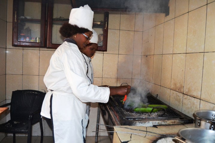 Uwimpuhwe, umukobwa ukora akazi ko gucoma arimo kotsa ibitoki.