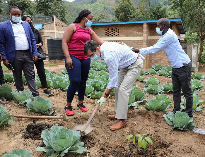 Mr.Keith Hansen uhagarariye Banki y'Isi mu Rwanda afatanyije n'abakozi muri MINEDUC bakoze umuganda mu mirima y'igikoni