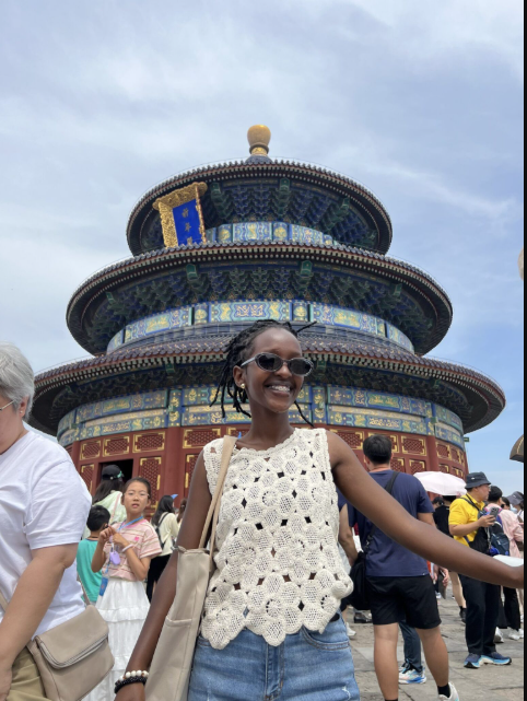 Isimbi Melissa, umwanditsi ahagaze ku nzu nyobokamana yiswe Temple of Heaven